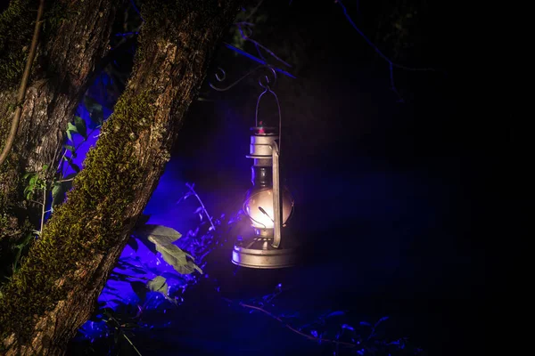 Concepto de Halloween de horror. Quema vieja lámpara de aceite en el bosque por la noche. Paisaje nocturno de una escena de pesadilla . — Foto de Stock