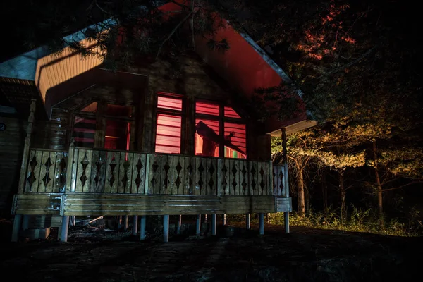 Casa velha com um fantasma na floresta à noite ou Abandonada Haunted Horror House no nevoeiro. Um velho edifício místico numa floresta de árvores mortas. Árvores à noite com lua. Luzes surreais. Conceito de Halloween horrível — Fotografia de Stock