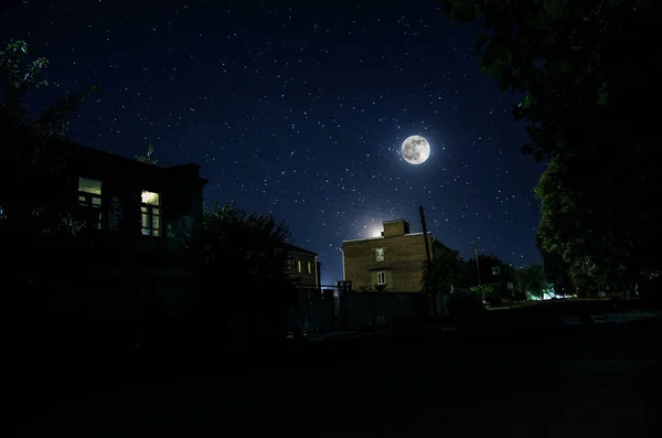 Luna piena su un bel villaggio di notte. Bellissimo paesaggio notturno di strada della città vecchia con luci. Russia — Foto Stock
