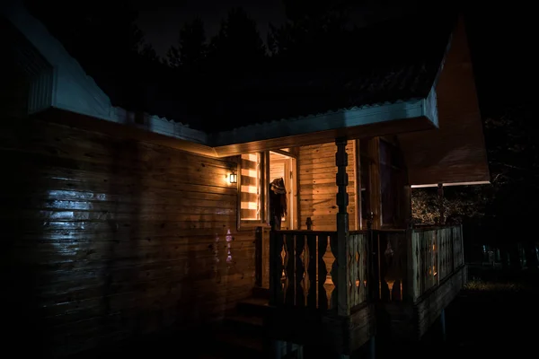 Gammalt hus med en Ghost i skogen på natten eller Övergiven Haunted Horror House i dimma. Gammal mystisk byggnad i död trädskog. Träd på natten med månen. Surrealistiska ljus. Halloween-konceptet — Stockfoto