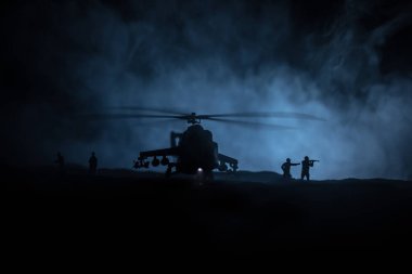 Askeri helikopter çatışma bölgesinden uçmaya hazır silüeti. Gece görüntüleri çöl sisli tonda sırt ile başlayarak helikopter ile dekore edilmiştir. Seçici odak.