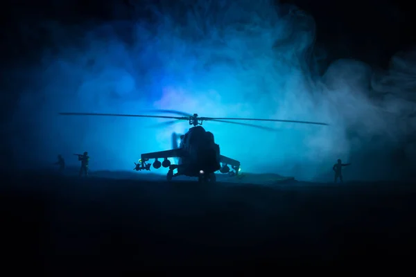 Silhouette of military helicopter ready to fly from conflict zone. Decorated night footage with helicopter starting in desert with foggy toned backlit. Selective focus. — Stock Photo, Image