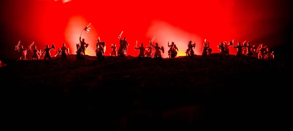 騎兵と歩兵と中世の戦闘シーン。別々のオブジェクトとしてのフィギュアのシルエットは、中世の城と暗い色調の霧の背景に戦士の間で戦います. — ストック写真