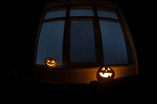 Abóbora de Halloween assustadora na janela mística da casa à noite ou abóbora de Halloween à noite no quarto com janela azul. Símbolo de Halloween em janela . — Fotografia de Stock