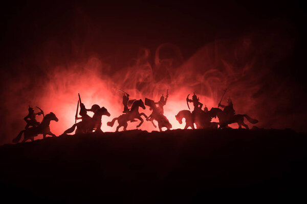 Средневековая боевая сцена с кавалерией и пехотой. Силуэты фигур как отдельные объекты, борьба между воинами на темном, тонированном туманном фоне со средневековым замком
.