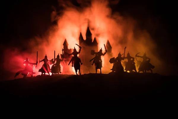 Mittelalterliche Kampfszene mit Kavallerie und Infanterie. Silhouetten von Figuren als separate Objekte, Kampf zwischen Kriegern auf dunkel getöntem Nebelhintergrund mit mittelalterlicher Burg. — Stockfoto