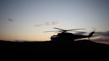 Askeri helikopter çatışma bölgesinden uçmaya hazır silüeti. Gece görüntüleri çöl sisli tonda sırt ile başlayarak helikopter ile dekore edilmiştir. Seçici odak.