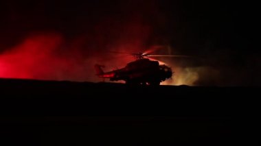 Askeri helikopter çatışma bölgesinden uçmaya hazır silüeti. Gece görüntüleri çöl sisli tonda sırt ile başlayarak helikopter ile dekore edilmiştir. Seçici odak.