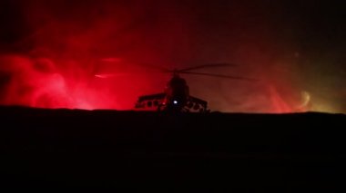 Askeri helikopter çatışma bölgesinden uçmaya hazır silüeti. Gece görüntüleri çöl sisli tonda sırt ile başlayarak helikopter ile dekore edilmiştir. Seçici odak.