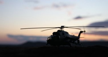 Askeri helikopter çatışma bölgesinden uçmaya hazır silüeti. Gece görüntüleri çöl sisli tonda sırt ile başlayarak helikopter ile dekore edilmiştir. Seçici odak.