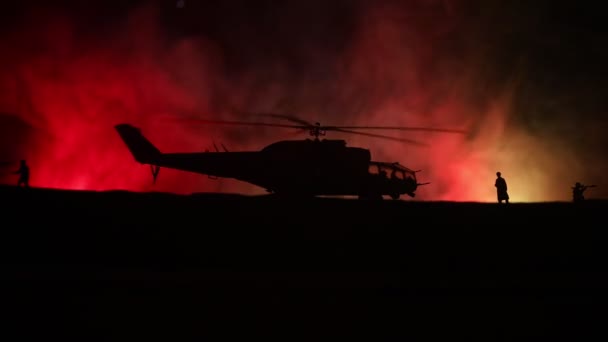 Silhueta de helicóptero militar pronta para voar da zona de conflito. Filmagem noturna decorada com helicóptero começando no deserto com nevoeiro tonificado retroiluminado. Foco seletivo . — Vídeo de Stock