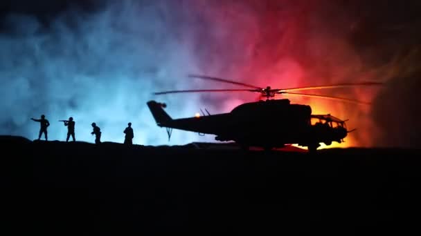 Silueta de helicóptero militar lista para volar desde zona de conflicto. Imágenes nocturnas decoradas con helicóptero comenzando en el desierto con niebla tonificada retroiluminada. Enfoque selectivo . — Vídeo de stock