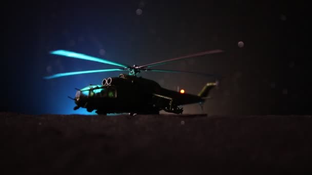 Silhueta de helicóptero militar pronta para voar da zona de conflito. Filmagem noturna decorada com helicóptero começando no deserto com nevoeiro tonificado retroiluminado. Foco seletivo . — Vídeo de Stock