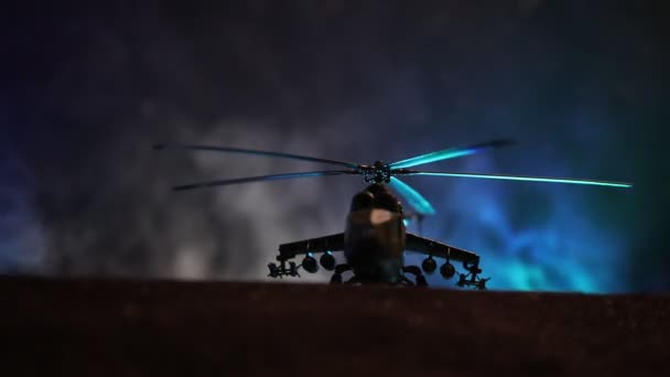 Silhouette di elicottero militare pronto a volare dalla zona di conflitto. Filmato notturno decorato con elicottero che inizia nel deserto con nebbia tonica retroilluminata. Focus selettivo . — Video Stock