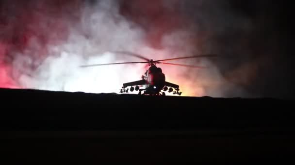 Silhouette di elicottero militare pronto a volare dalla zona di conflitto. Filmato notturno decorato con elicottero che inizia nel deserto con nebbia tonica retroilluminata. Focus selettivo . — Video Stock