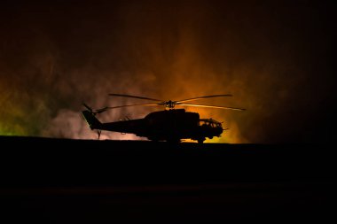 Askeri helikopter çatışma bölgesinden uçmaya hazır silüeti. Gece görüntüleri çöl sisli tonda sırt ile başlayarak helikopter ile dekore edilmiştir. Seçici odak.