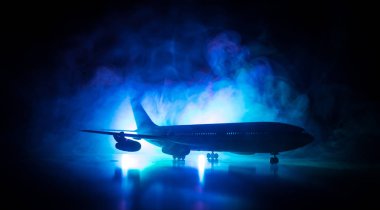 Sanat dekorasyonu. Beyaz yolcu uçağı havaalanı pistinden kalkışa hazır. Gece saatlerinde Uçak Silueti.