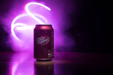 Bakü, Azerbaycan - 15 Eylül 2019: Koyu tonlu sisli arka planda ışıkla birlikte Dr Pepper'ın meşrubata bakması. Dr Pepper eşsiz bir lezzete sahip olarak pazarlanan bir meşrubat.
