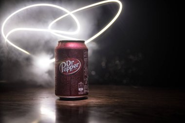 Bakü, Azerbaycan - 15 Eylül 2019: Koyu tonlu sisli arka planda ışıkla birlikte Dr Pepper'ın meşrubata bakması. Dr Pepper eşsiz bir lezzete sahip olarak pazarlanan bir meşrubat.