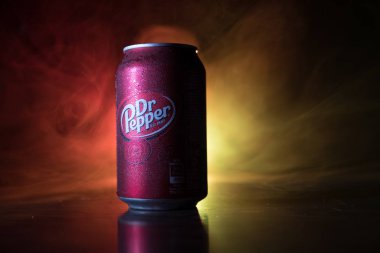 Bakü, Azerbaycan - 15 Eylül 2019: Koyu tonlu sisli arka planda ışıkla birlikte Dr Pepper'ın meşrubata bakması. Dr Pepper eşsiz bir lezzete sahip olarak pazarlanan bir meşrubat.