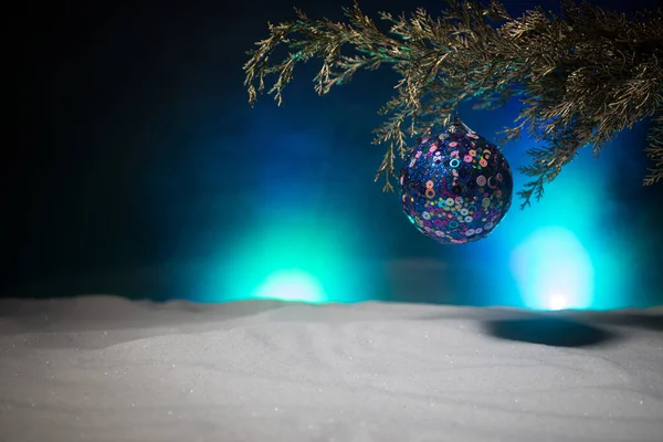 La decoración Navideña - la chuchería sobre la rama del pino con los atributos de fiesta sobre la nieve. Enfoque selectivo — Foto de Stock