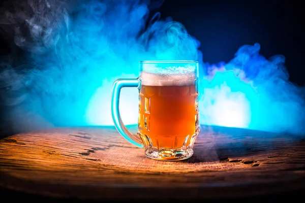 Kreatives Konzept. Biergläser auf Holztisch vor dunkel getöntem Nebelhintergrund. — Stockfoto