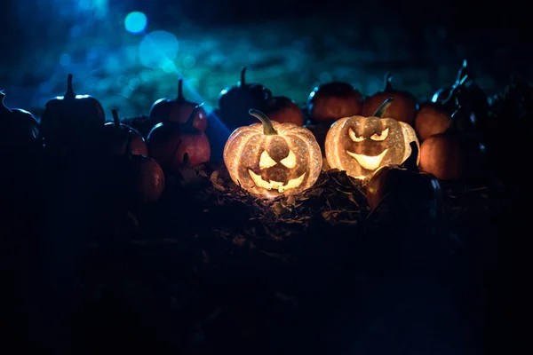 Хэллоуин Джек-о-фонарь на осенних листьях. Страшная тыква на Хэллоуин смотрит сквозь дым. Светящийся , — стоковое фото