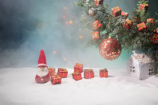 Christmas Decoration - bauble on branch of pine tree with holiday attributes on snow. Selective focus — Stock Photo, Image