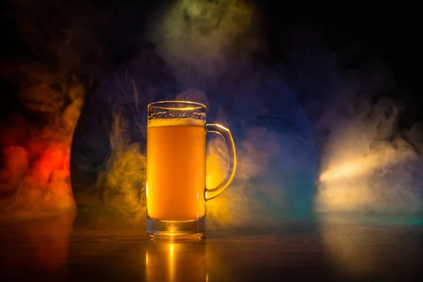 Creative concept. Beer glasses on wooden table at dark toned foggy background. — Stock Photo, Image