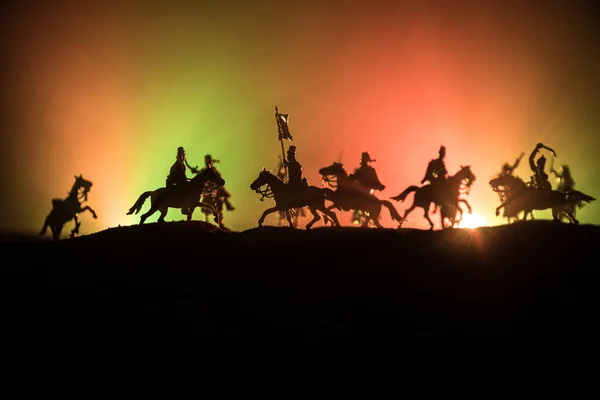 Cena de batalha medieval com cavalaria e infantaria. Silhuetas de figuras como objetos separados, luta entre guerreiros em fundo enevoado escuro. Cena noturna . — Fotografia de Stock