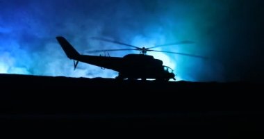 Askeri helikopter çatışma bölgesinden uçmaya hazır silüeti. Gece görüntüleri çöl sisli tonda sırt ile başlayarak helikopter ile dekore edilmiştir. Seçici odak.