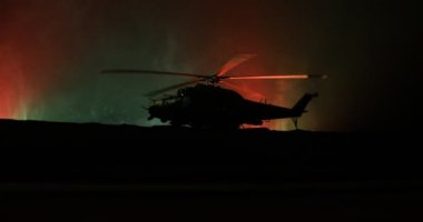 Askeri helikopter çatışma bölgesinden uçmaya hazır silüeti. Gece görüntüleri çöl sisli tonda sırt ile başlayarak helikopter ile dekore edilmiştir. Seçici odak.