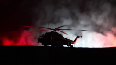 Askeri helikopter çatışma bölgesinden uçmaya hazır silüeti. Gece görüntüleri çöl sisli tonda sırt ile başlayarak helikopter ile dekore edilmiştir. Seçici odak.
