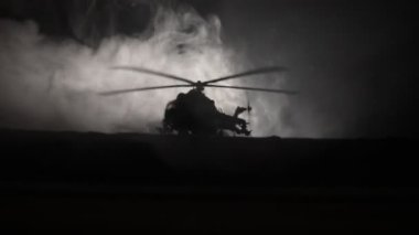 Askeri helikopter çatışma bölgesinden uçmaya hazır silüeti. Gece görüntüleri çöl sisli tonda sırt ile başlayarak helikopter ile dekore edilmiştir. Seçici odak.