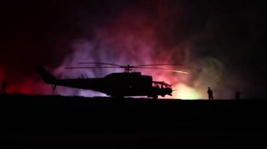 Askeri helikopter çatışma bölgesinden uçmaya hazır silüeti. Gece görüntüleri çöl sisli tonda sırt ile başlayarak helikopter ile dekore edilmiştir. Seçici odak.