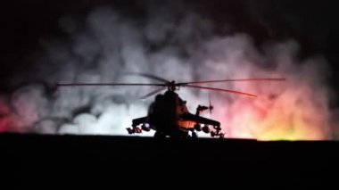 Askeri helikopter çatışma bölgesinden uçmaya hazır silüeti. Gece görüntüleri çöl sisli tonda sırt ile başlayarak helikopter ile dekore edilmiştir. Seçici odak.
