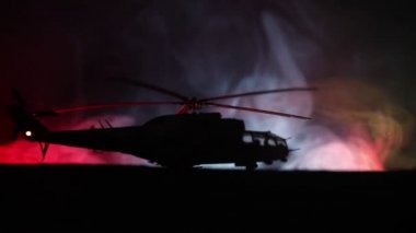 Askeri helikopter çatışma bölgesinden uçmaya hazır silüeti. Gece görüntüleri çöl sisli tonda sırt ile başlayarak helikopter ile dekore edilmiştir. Seçici odak.