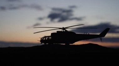 Askeri helikopter çatışma bölgesinden uçmaya hazır silüeti. Gece görüntüleri çöl sisli tonda sırt ile başlayarak helikopter ile dekore edilmiştir. Seçici odak.