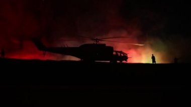 Askeri helikopter çatışma bölgesinden uçmaya hazır silüeti. Gece görüntüleri çöl sisli tonda sırt ile başlayarak helikopter ile dekore edilmiştir. Seçici odak.