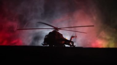 Askeri helikopter çatışma bölgesinden uçmaya hazır silüeti. Gece görüntüleri çöl sisli tonda sırt ile başlayarak helikopter ile dekore edilmiştir. Seçici odak.