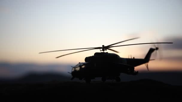 Silhouette d'hélicoptère militaire prêt à décoller de la zone de conflit. Images de nuit décorées avec hélicoptère commençant dans le désert avec rétroéclairage tonique brumeux. Concentration sélective . — Video