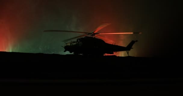 Silhueta de helicóptero militar pronta para voar da zona de conflito. Filmagem noturna decorada com helicóptero começando no deserto com nevoeiro tonificado retroiluminado. Foco seletivo . — Vídeo de Stock