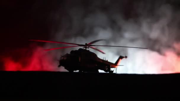 Silhouet van militaire helikopter klaar om te vliegen vanaf conflictgebied. Nacht beelden versierd met helikopter starten in woestijn met mistige afgezwakt achtergrondverlichting. Selectieve aandacht. — Stockvideo