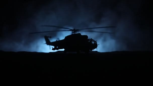 Silhueta de helicóptero militar pronta para voar da zona de conflito. Filmagem noturna decorada com helicóptero começando no deserto com nevoeiro tonificado retroiluminado. Foco seletivo . — Vídeo de Stock