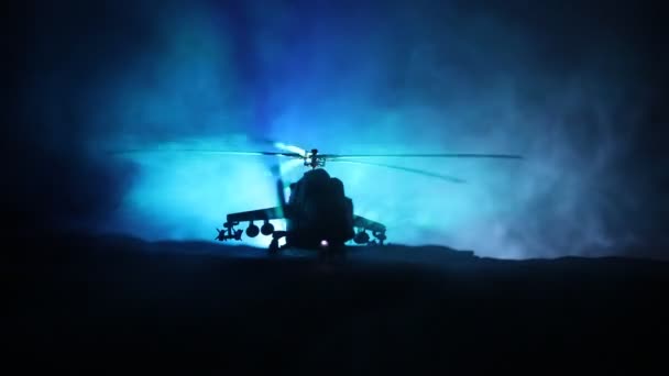 Sylwetka wojskowego helikoptera gotowy do lotu od strefy konfliktu. Ozdobione noc nagrania śmigłowca począwszy od pustyni z mglisty stonowanych podświetlany. Selektywny fokus. — Wideo stockowe
