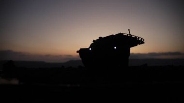 Savaş Konsepti. Savaş sis gökyüzü arka plan üzerinde sahne mücadele Askeri siluetler, Gece Bulutlu Skyline Altında Dünya Savaşı Alman Tankları Siluetler. Saldırı sahnesi. Zırhlı araçlar ve piyadeler.