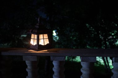 Retro tarzı fener geceleri. Bahçede balkonda güzel renkli ışıklı lamba.