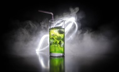 Kokteyl cam koyu tonda dumanlı arka plan veya cam renkli kokteyl sıçrayan. Parti kulübü eğlencesi. Karışık ışık.