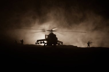 Askeri helikopter çatışma bölgesinden uçmaya hazır silüeti. Gece görüntüleri çöl sisli tonda sırt ile başlayarak helikopter ile dekore edilmiştir. Seçici odak.