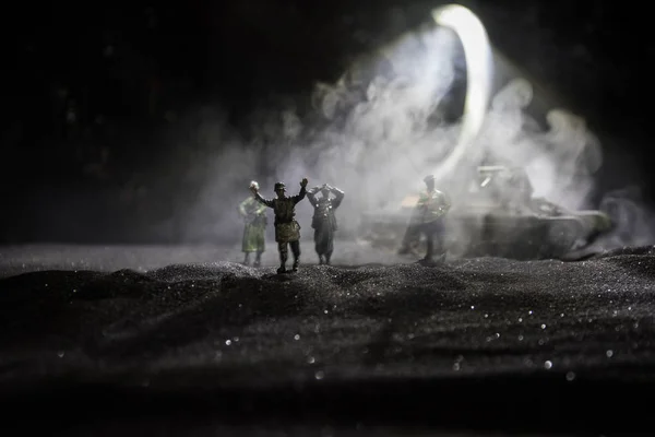 Gevechtsscène. Militaire silhouetten vechten scène op oorlog mist hemel achtergrond. Een Duitse soldaat verhoogde de armen tot overgave. Plastic speelgoed soldaten met geweren die de vijandelijke soldaat gevangen nemen. — Stockfoto